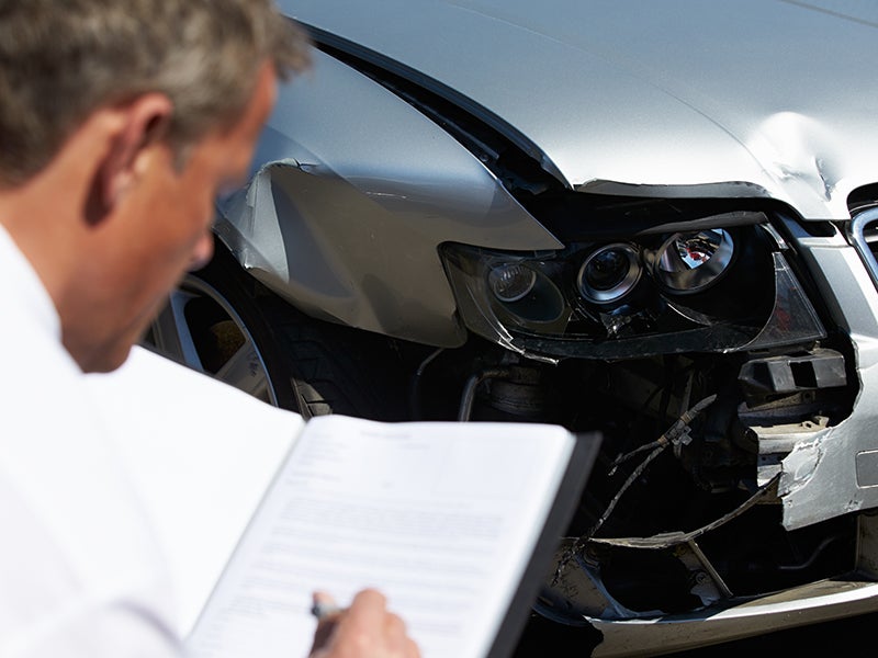 car mechanic inspecting car damage