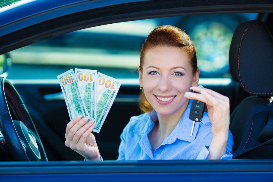 The lady is holding money and a car key in her hand
